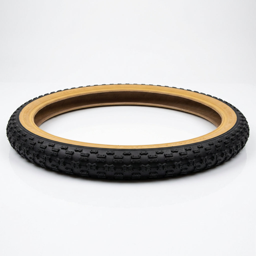 16 x 1.75 gumwall bike tyre laid flat, showing its circular shape and tan sidewalls.
